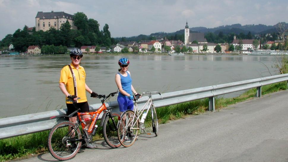 Gerhard und Babsi am Donauradweg. Im Hintergrund das Schloss und die Stadt Grein